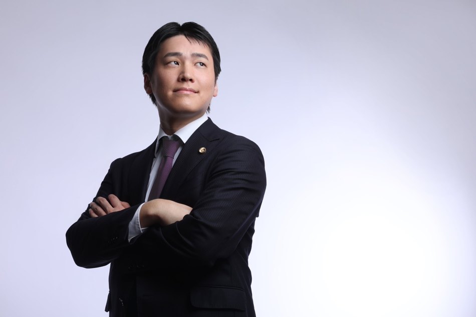 腕を組んで前方を見る浦川ゆうすけ