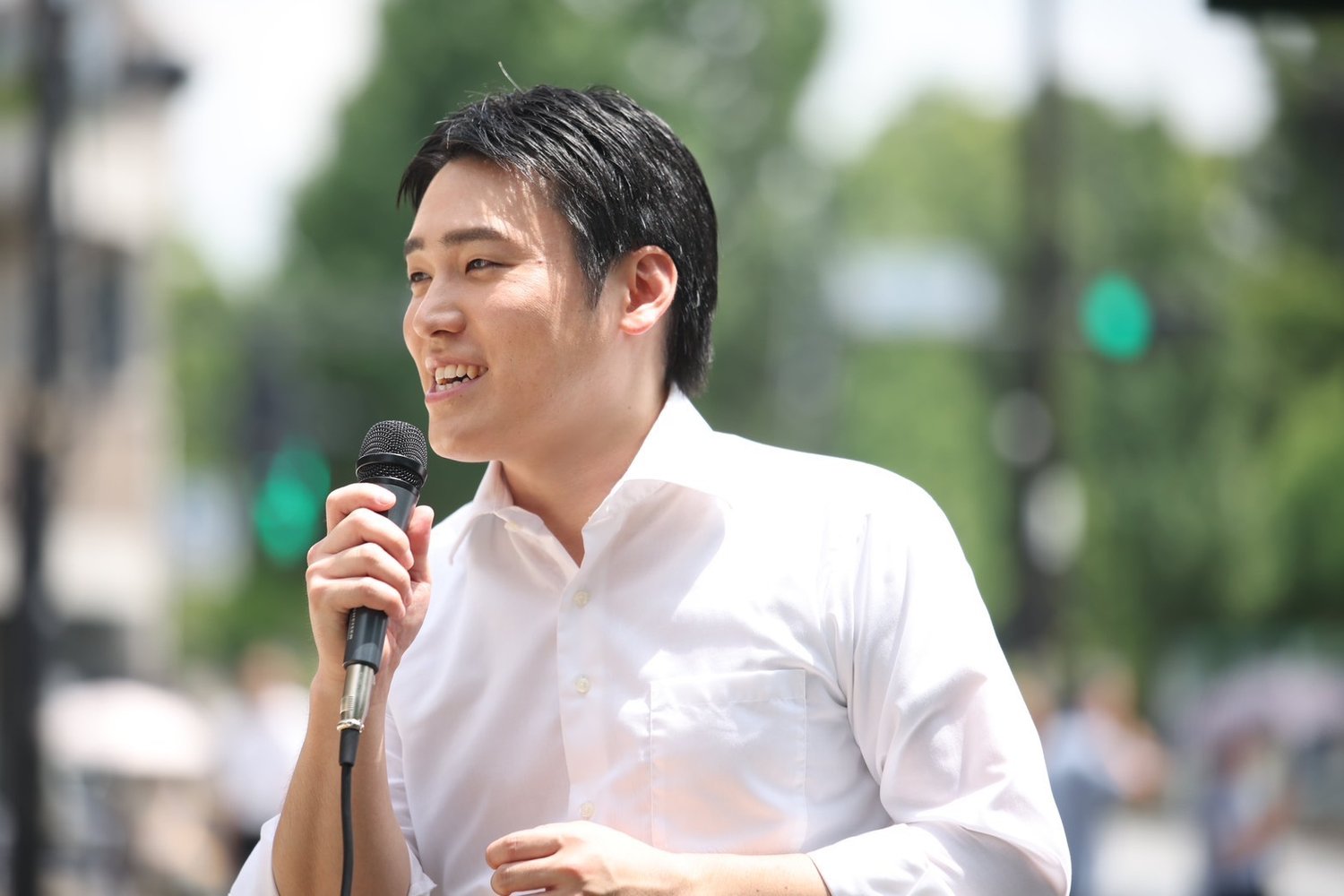 白いシャツ姿でマイクを手に話す浦川ゆうすけ