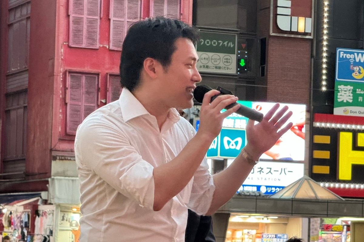 街頭で身振りを交えながらマイクで話す浦川ゆうすけ