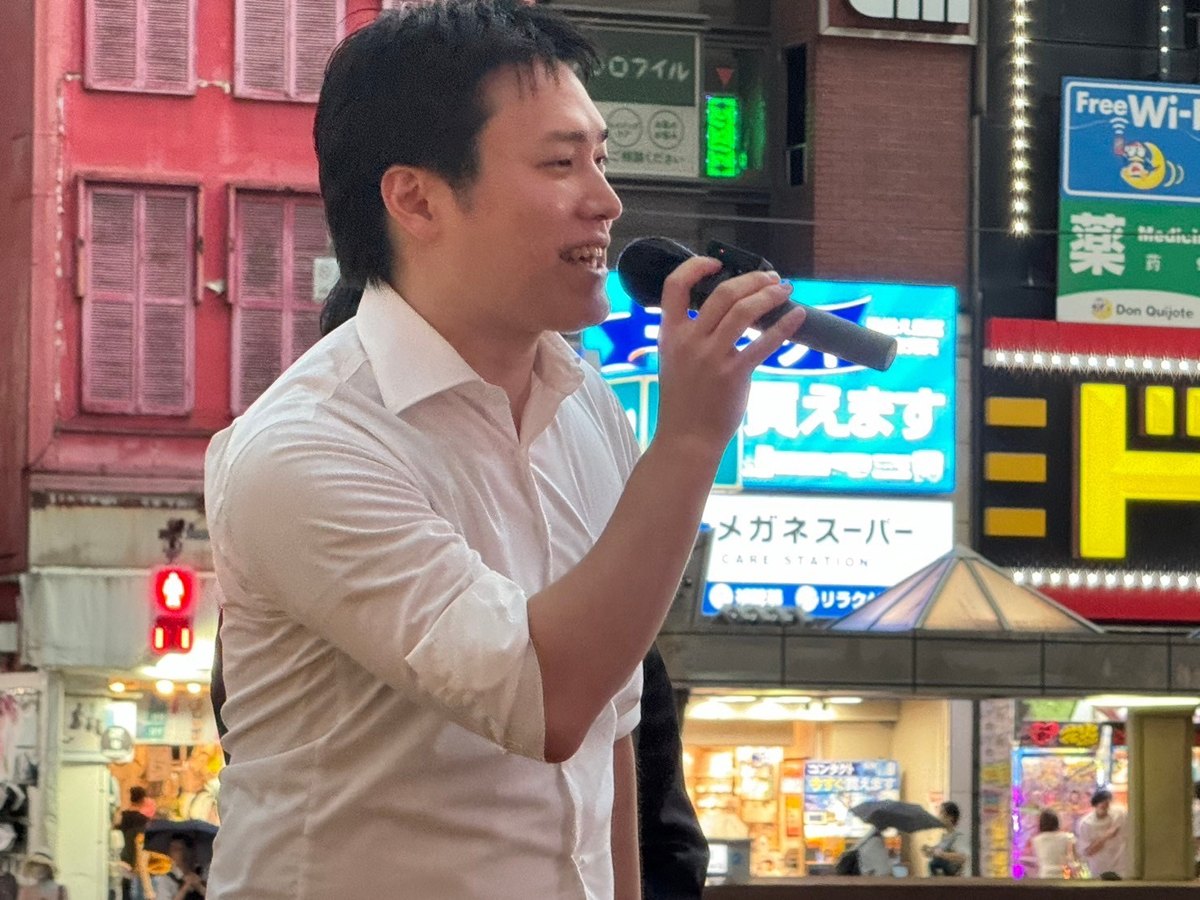 街頭でマイクを持ち、笑顔で話す浦川ゆうすけ
